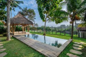 a resort pool with a wooden bridge and a hut at Sola Villa Ubud in Ubud +33 photos