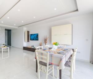 a white dining room with a table and chairs at New Spacious Apartment 3 Bdr 2 Bth Bugibba in St Paul's Bay