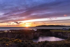 a sunset over a body of water with the ocean at Sheerghlass in Castletown