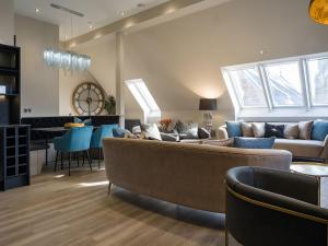 a living room with a couch and a table at Arran Shores Luxury Shorefront Penthouse Suite 10 in Lamlash