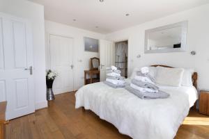 a white bedroom with a bed with towels on it at Sheerghlass in Castletown