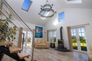 a living room with a staircase and a chandelier at Sheerghlass in Castletown