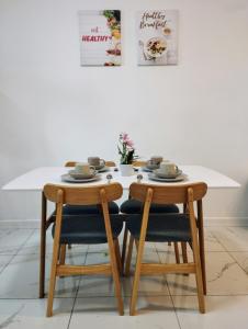 una mesa de madera con 2 sillas y una mesa blanca en Cubic Botanical Bangsar South, en Kuala Lumpur