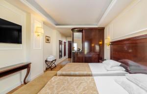 a hotel room with two beds and a flat screen tv at Hotel President Solin in Solin +61 photos