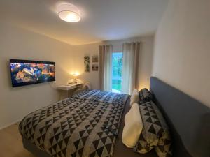 a bedroom with a bed and a tv on the wall at SLEEP WELL Apartments DETMOLD - Tempur Beds- NEU - Top Lage - Free parking - WIFI in Detmold
