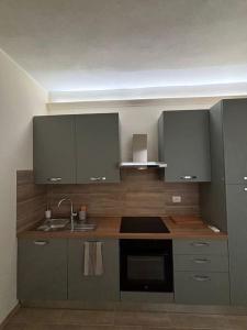 a kitchen with gray cabinets and a sink at A due passi da Piazza Cavalli in Piacenza