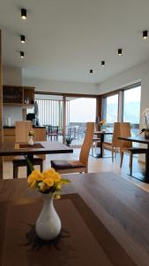 アッピアーノ・スッラ・ストラーダ・デル・ヴィーノにあるHighlight Apartmentsの花瓶のあるリビングルーム(テーブル付)