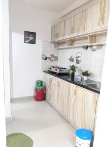a kitchen with wooden cabinets and a red trash can at C Suites - Cape Town in Bengaluru
