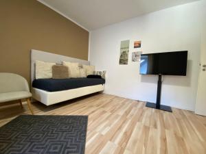 a living room with a bed and a flat screen tv at SLEEP WELL Apartments DETMOLD - Tempur Beds- NEU - Top Lage - Free parking - WIFI in Detmold
