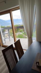 a dining room table with two chairs and a large window at Highlight Apartments in Appiano sulla Strada del Vino +67 photos