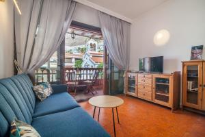 Una sala de estar con un sofá azul y un televisor. en PARAISO BAMBOO - 2 bedrooms, 2 bathrooms, fibre net, heart of the Los Gigantes, tv channels, en Acantilado de los Gigantes