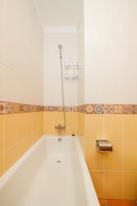 y baño con bañera y azulejos de color naranja y blanco. en PARAISO BAMBOO - 2 bedrooms, 2 bathrooms, fibre net, heart of the Los Gigantes, tv channels, en Acantilado de los Gigantes 19 fotos más