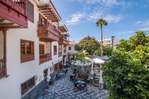 Un patio al aire libre con mesas y sillas en un edificio. en PARAISO BAMBOO - 2 bedrooms, 2 bathrooms, fibre net, heart of the Los Gigantes, tv channels, en Acantilado de los Gigantes