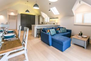 a living room with a blue couch and a table at Seashells Bracklesham Bay in Chichester