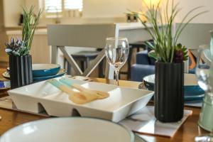 a dining room table with a plate and a glass at Seashells Bracklesham Bay in Chichester