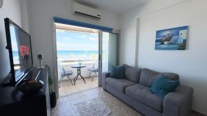 ラルナカにあるKolonaki Seaview 1BDR Finikoudesのソファがあり海が見えるリビングルーム