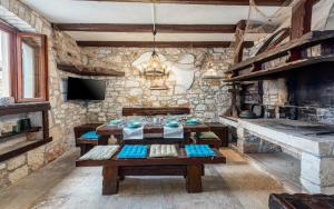 a living room with a table and a stone wall at Rustic stone holiday house with pool in Marčana