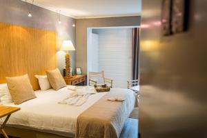 a bedroom with a bed and a table with a lamp at Hotel de Charme Le Sud Bretagne in Pornichet