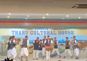 um grupo de pessoas dançando em frente a uma grande faixa em BhupuSainik Guest House - Sauraha, Chitwan em Sauraha