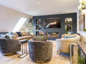a living room with couches and a fireplace at Arran Shores Luxury Shorefront Penthouse Suite 13 in Lamlash