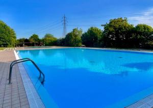 una gran piscina azul con agua azul en Wendy Apartment- Twobedroom & Pool & ParkPrivateFree & Sports, en Desenzano del Garda