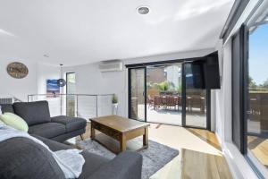 a living room with a couch and a table at Coastal Escape on Highlander in Torquay