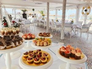 a table filled with different types of cakes and pastries at Boutique Citadel in Eforie Nord