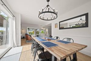a dining room with a wooden table and a chandelier at Farmhouse 1918 Grand Retreat for 12 people with Lake Views in Boyne City