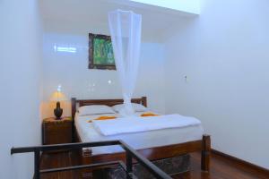 a bedroom with a bed with a mosquito net at Tirta Yoga Inn in Padangbai