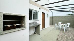 a patio with a table and chairs and a building at Residencial Praia do Sonho - PLH002 in Ilha dos Cardos +7 photos