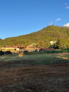 a field with a hill in the background with a fence at Camping en granja los nogales in Pátzcuaro