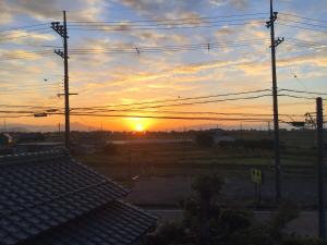 una puesta de sol sobre un campo con muchos cables en FarmStayINN 母屋 Sanzaemon-tei GuestHouse Second floor Shiga-Takasima Traditional Japanese architecture house Limited to one group per day, en Takashima