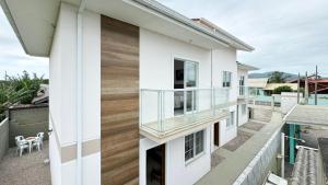 a house with a glass railing on the balcony at Residencial Praia do Sonho - PLH002 in Ilha dos Cardos