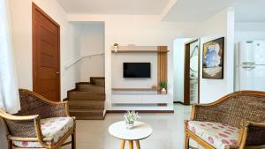 a living room with two chairs and a tv at Residencial Praia do Sonho - PLH002 in Ilha dos Cardos