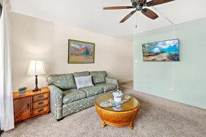 una sala de estar con un sofá y una mesa en Paki Maui 313, en Kahana
