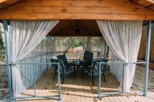 a screened in porch with a table and chairs at Котеджне містечко «Clover» in Vylkove