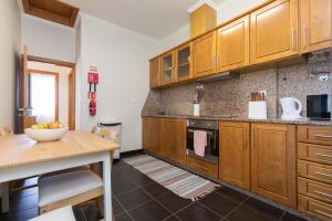 een grote keuken met houten kasten en een tafel bij Casa da Jackie in Funchal