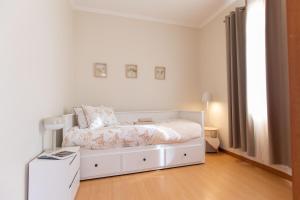een witte slaapkamer met een bed en een tafel bij Casa da Jackie in Funchal