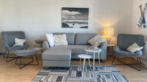 un soggiorno con un divano e due poltrone di Simmerdeis am Hafen a Husum