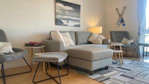 un soggiorno con un divano e una sedia di Simmerdeis am Hafen a Husum