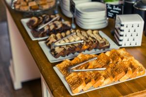 a buffet filled with different types of pastries on plates at Hotel de Charme Le Sud Bretagne in Pornichet +38 photos