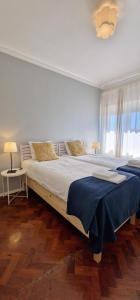 a bedroom with two large beds with blue sheets at Beautiful view close to Estádio da Luz in Lisbon