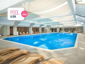 a large swimming pool in a hotel with chairs at Hotel Excelsior - Liburnia in Lovran