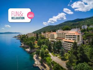 arial view of a resort on a lake with a mountain at Hotel Excelsior - Liburnia in Lovran