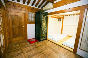 een kleine kamer met een bed en een deur bij Bukchonmaru Hanok Guesthouse in Seoul
