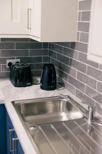 een aanrecht met een wastafel en een broodrooster bij River Walk Apartments in Derry Londonderry