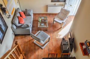 vista sul soffitto di un soggiorno con divano e sedie di Acogedora casa con verde jardín by CABANA Rentals a Ituero y Lama