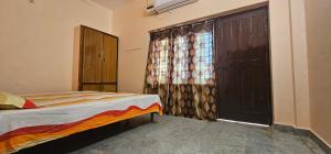 Giường trong phòng chung tại 2Ground Lawn Bedroom Indian Toilet