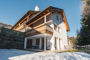 a large white house with a wooden roof at ALPSTAY Platzhirsch - Ski-In & Ski-Out in Bad Kleinkirchheim