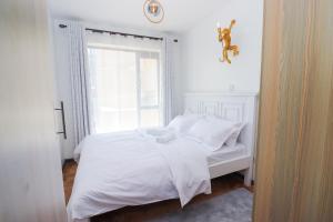 ナイロビにあるInferno Retreat at Royal surburbs by Tsavoの窓のある部屋にある白いベッド